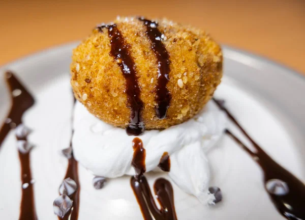 Helado frito con jarabe de chocolate y crema en el plato — Foto de Stock