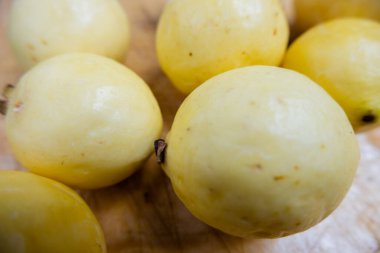 Tahta bir masada taze sarı guavalar.