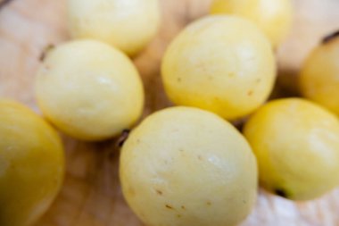 Tahta bir masada taze sarı guavalar.