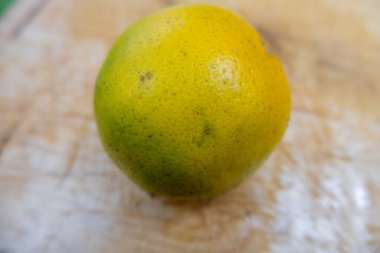 Çizik ahşap bir masada taze portakal.