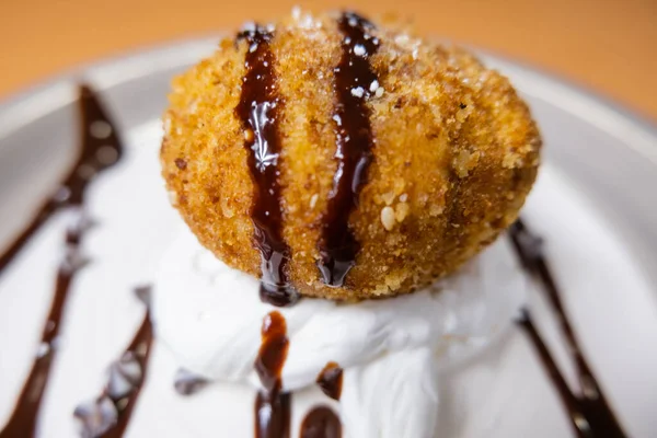 Helado frito con jarabe de chocolate y crema en el plato — Foto de Stock