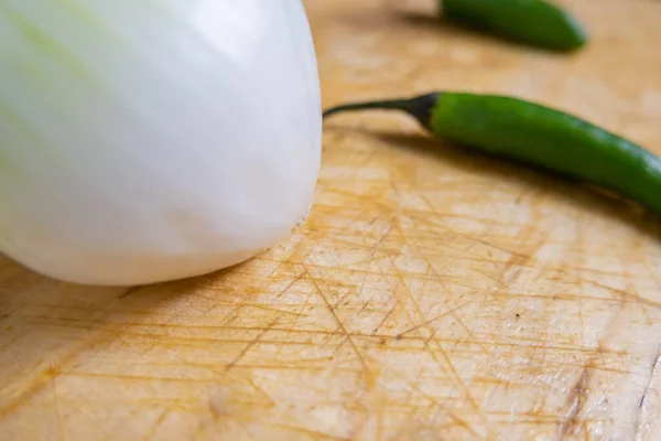 Friss chili paprika és hagyma izolálva egy fa asztalon — Stock Fotó