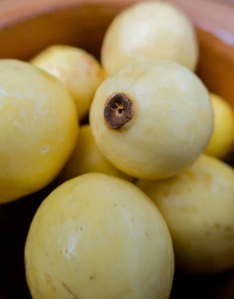 Fresh yellow guavas in a handmade clay bowl — Stock Photo, Image