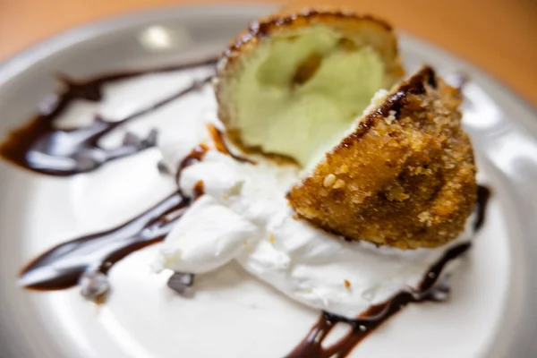 Helado frito con jarabe de chocolate y crema en el plato — Foto de Stock