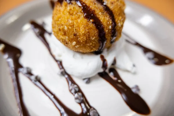 Helado frito con jarabe de chocolate y crema en el plato — Foto de Stock