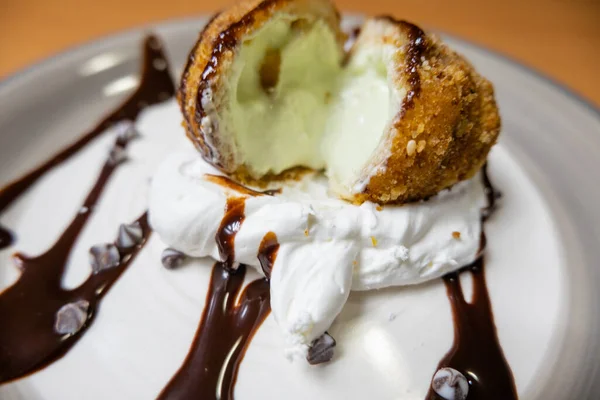 Helado frito con jarabe de chocolate y crema en el plato — Foto de Stock