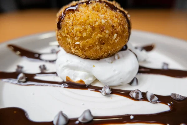 Helado frito con jarabe de chocolate y crema en el plato — Foto de Stock