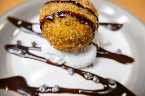 Helado frito con jarabe de chocolate y crema en el plato — Foto de Stock