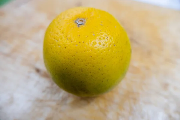 Laranja fresca isolada numa mesa de madeira riscada — Fotografia de Stock