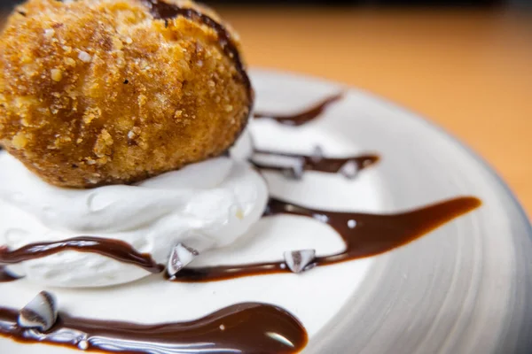 Helado frito con jarabe de chocolate y crema en el plato — Foto de Stock