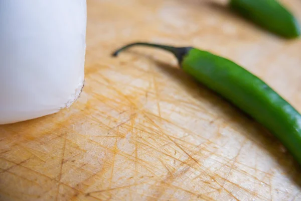 Friss chili paprika és hagyma izolálva egy fa asztalon — Stock Fotó