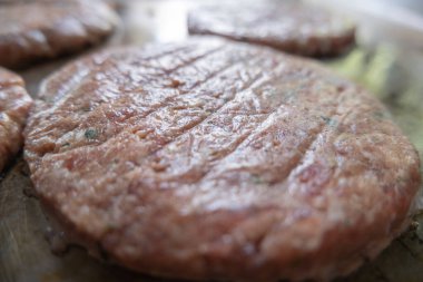 Büyük bir tavada kızarmış hamburger eti.