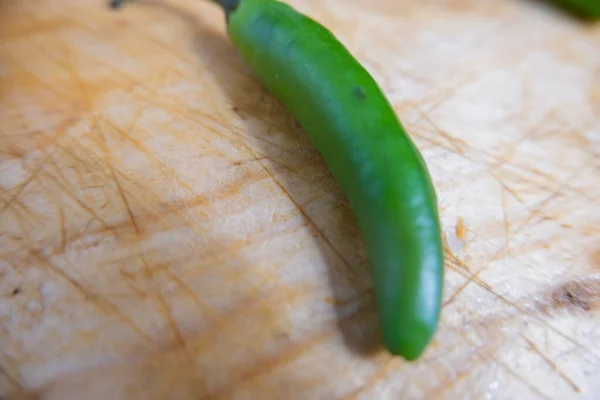 Färsk chilipeppar isolerad på ett träbord — Stockfoto