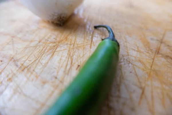 Pimenta fresca e cebola isoladas em uma mesa de madeira — Fotografia de Stock