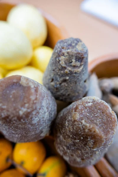 Canne da zucchero marrone scuro tra ciotole di argilla di frutta — Foto Stock