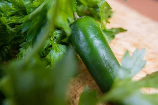 Groene chili peper en koriander op een houten tafel — Stockfoto