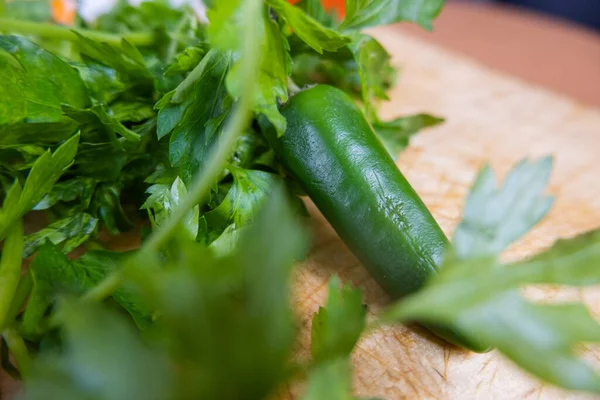 Groene chili peper en koriander op een houten tafel — Stockfoto