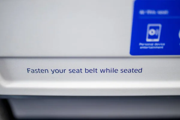Texto solicitando a los pasajeros que abrochen sus cinturones de seguridad en el avión — Foto de Stock