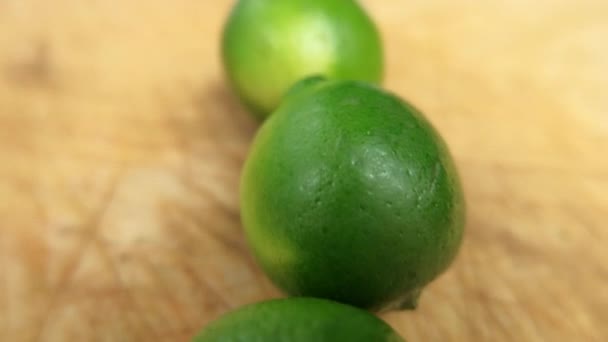 Limes fresco isolato su un tavolo di legno graffiato — Video Stock