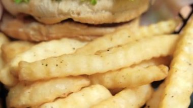 Patates kızartması ve hamburgeri siyah sepete koy.