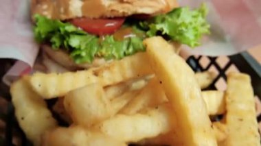 Patates kızartması ve hamburgeri siyah sepete koy.