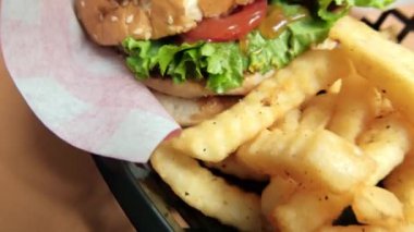 Patates kızartması ve hamburgeri siyah sepete koy.