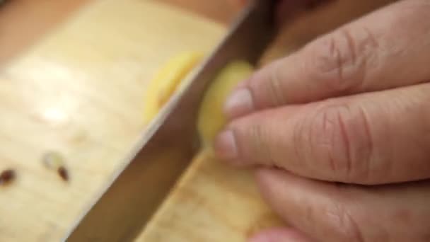Mãos cuidadosamente cortando goiabas acima de uma tábua de corte — Vídeo de Stock