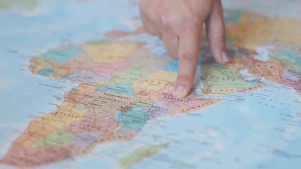 Weibliche Hand zeigt auf eine bunte Landkarte Afrikas — Stockvideo