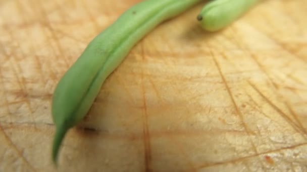 Groene bonen geïsoleerd op een bekrast houten tafel — Stockvideo