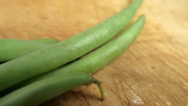 Green beans isolated on a scratched wooden table — Stock Video