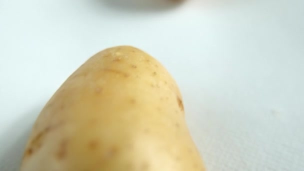 Close-up of fresh potatoes isolated on a white table — Stock Video