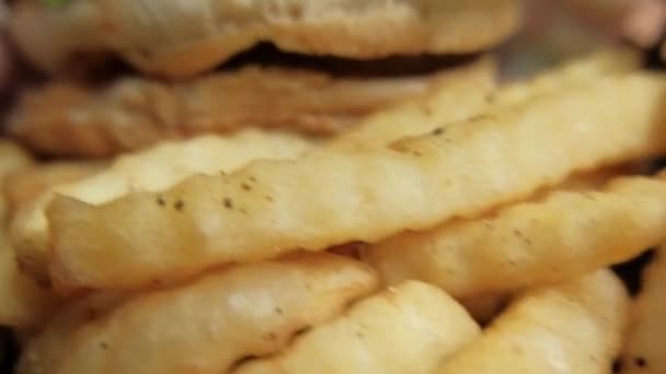 Nahaufnahme von Pommes und Hamburger in einem schwarzen Korb — Stockvideo