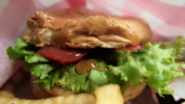 Close-up dari hamburger dan kentang goreng dalam keranjang hitam — Stok Video