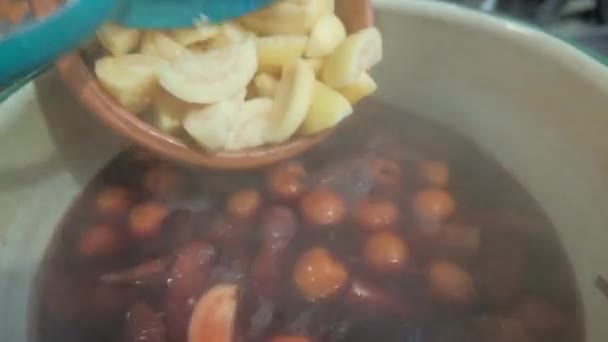 Pouring guava slices with spoon into hot Mexican punch — Stock Video