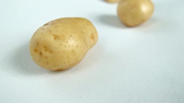 Крупный план свежего картофеля, изолированного на белом столе — стоковое видео