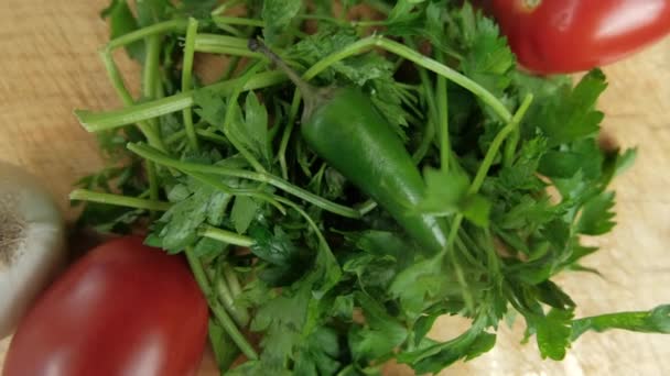 Zielona papryka chili i kolendra na drewnianym stole — Wideo stockowe