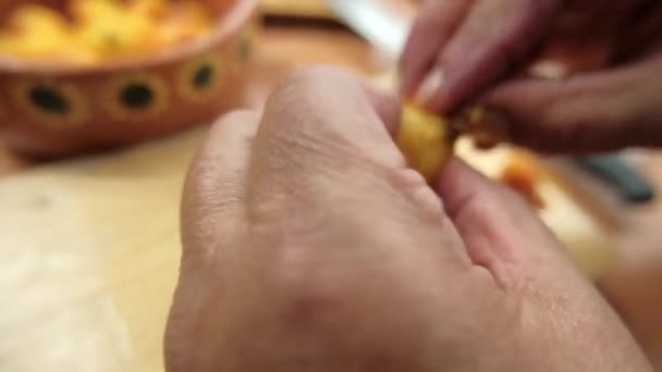 Hands carefully peeling Mexican hawthorns above cutting board — Stock Video