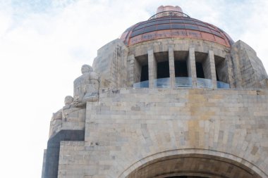 Hafifçe bulutlu mavi gökyüzünün altında Devrim anıtı