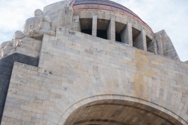 Hafifçe bulutlu mavi gökyüzünün altında Devrim anıtı