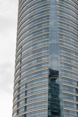 Arka planda bulutlu gökyüzü olan büyük ofis binası