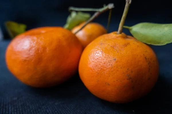 Tangerines isolated on a table with dark tablecloth — Stock Photo, Image