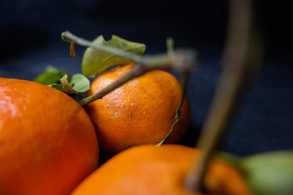 Tangerines isolated on a table with dark tablecloth — Stock Photo, Image