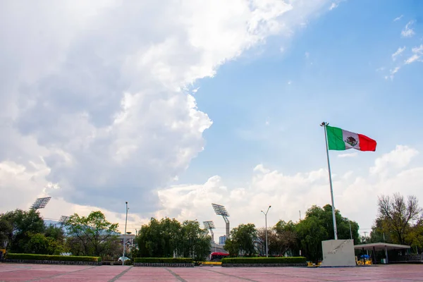 Wavy mexikói zászló nyilvános téren egy felhős ég, mint a háttér — Stock Fotó