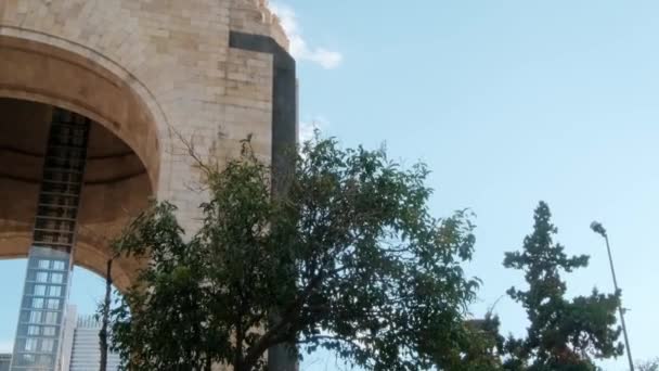 Arbres à côté du monument de la révolution avec le ciel bleu comme arrière-plan — Video