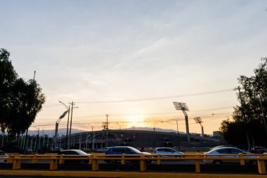 Arka planda güzel bir gündoğumu olan Meksika üniversitesinden stadyum.