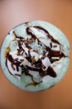Çikolata parçacıklı milkshake ve masada şurup.