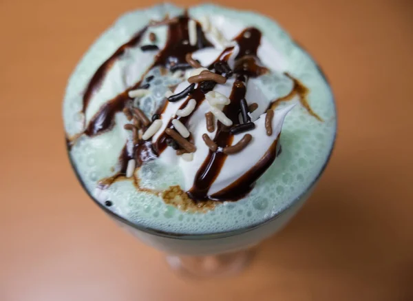 Milkshake with chocolate chips and syrup on a table — Stock Photo, Image