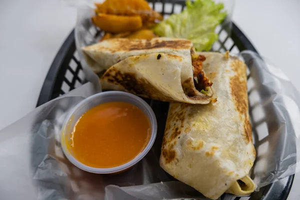 Burritos de cerdo picante y lechuga en una canasta de plástico —  Fotos de Stock