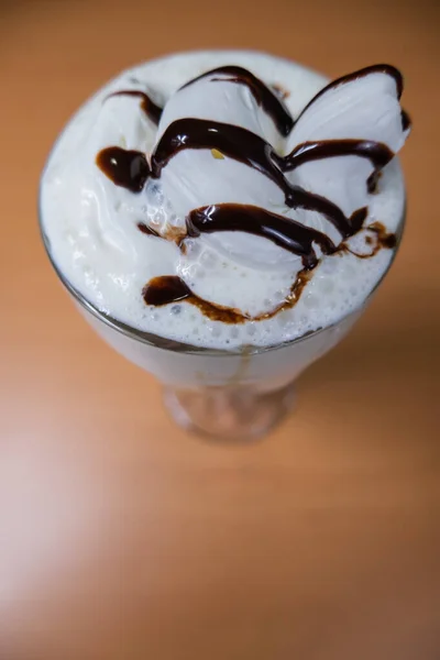 Milkshake de baunilha com xarope de chocolate em uma mesa — Fotografia de Stock