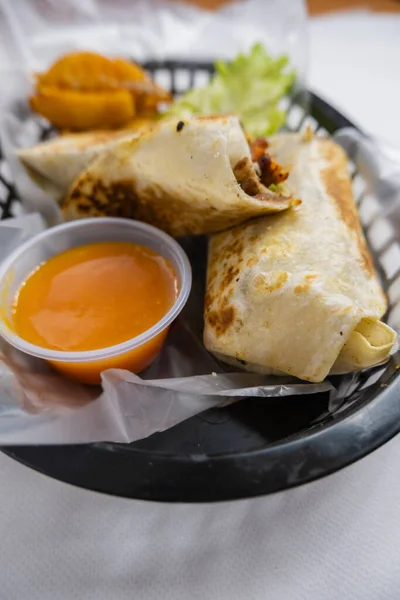 Burritos de cerdo picante y lechuga en una canasta de plástico —  Fotos de Stock